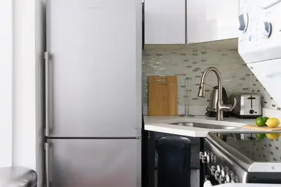 a kitchen with a refrigerator and a sink at 24-10 Studio in Prime Gramercy WD in Unit in New York