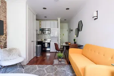 a living room with a couch and a kitchen at 24-10 Studio in Prime Gramercy WD in Unit in New York