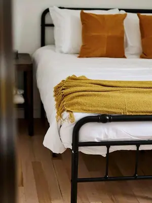 a bed with a yellow blanket on top of it at Chic Renovated Chalet with Private Pond in Roscoe