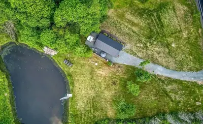an aerial view of a house next to a lake at Chic Renovated Chalet with Private Pond in Roscoe
