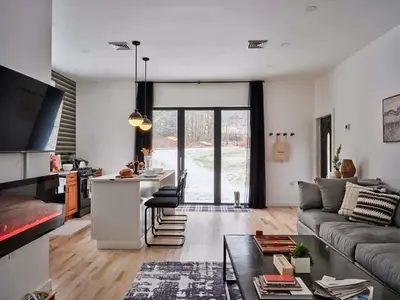 a kitchen and living room with a couch and a table at Chic Renovated Chalet with Private Pond in Roscoe