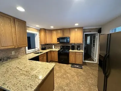 a kitchen with wooden cabinets and a black refrigerator at Iron Hill in Lake Harmony