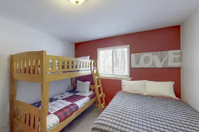a bedroom with two bunk beds and a love sign on the wall at Iron Hill in Lake Harmony