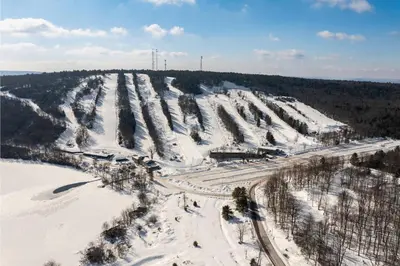 an aerial view of a snow covered hill with trees at Iron Hill in Lake Harmony