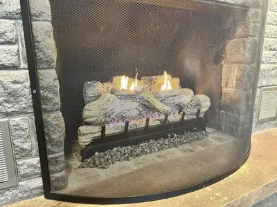 a stone fireplace with a fire in it at Iron Hill in Lake Harmony