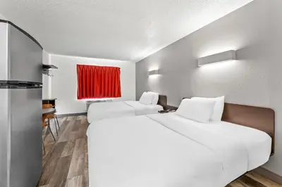 a hotel room with two beds and a red window at Studio 6 King of Prussia PA Philadelphia in King of Prussia