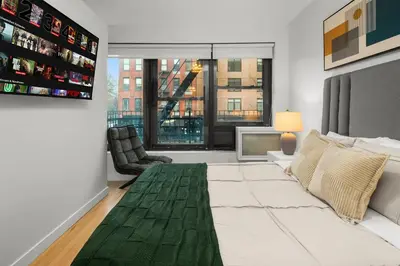 a living room with a bed and a large window at Beautiful Apartment in NYC in New York
