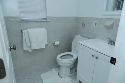 a bathroom with a white toilet and a sink at Spacious 3 Bedroom, 15 Min to EWR Airport and Parks in Newark