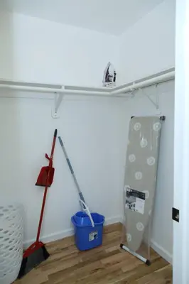 a room with a mop and a shelf on the wall at Spacious 3 Bedroom, 15 Min to EWR Airport and Parks in Newark