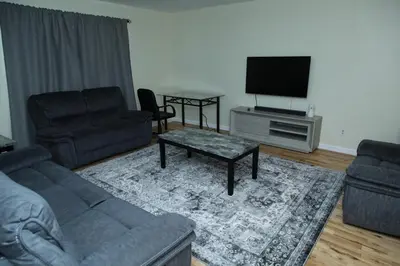 a living room with a couch and a flat screen tv at Spacious 3 Bedroom, 15 Min to EWR Airport and Parks in Newark