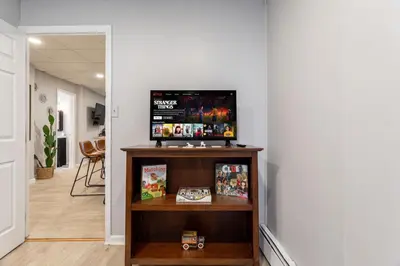 a room with a tv on top of a shelf at The Grand Retreat 9BR 4BA Near NYC and Airport in Bayonne