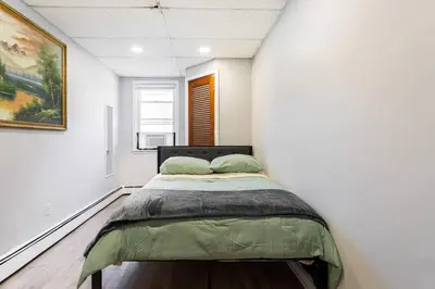 a bedroom with a bed in a white wall at The Grand Retreat 9BR 4BA Near NYC and Airport in Bayonne