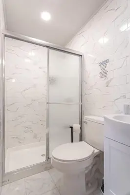 a bathroom with a shower and a toilet and a sink at The Grand Retreat 9BR 4BA Near NYC and Airport in Bayonne