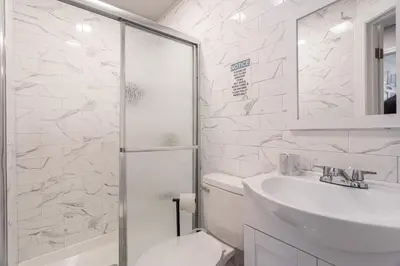 a bathroom with a toilet and a sink and a shower at The Grand Retreat 9BR 4BA Near NYC and Airport in Bayonne