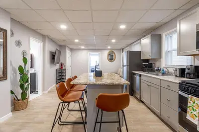 a kitchen with a table and chairs in a room at The Grand Retreat 9BR 4BA Near NYC and Airport in Bayonne