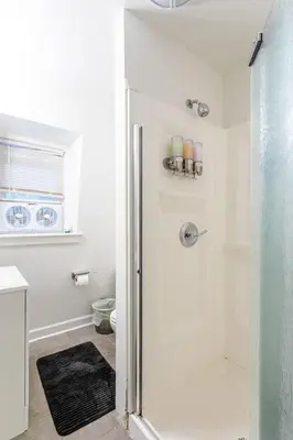 a shower with a glass door in a bathroom at Deluxe 4BR 2BA Apartment Near NYC and Airport in Bayonne