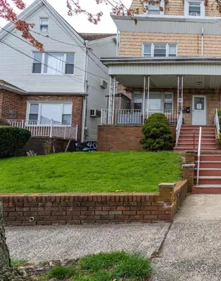 a house with a brick staircase in the front yard at Deluxe 4BR 2BA Apartment Near NYC and Airport in Bayonne