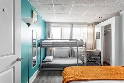 a room with two bunk beds and a desk at Spacious 4BR 1BA Duplex Apartment Near NYC in Bayonne