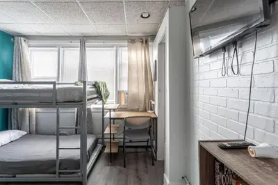 a dorm room with bunk beds and a desk at Spacious 4BR 1BA Duplex Apartment Near NYC in Bayonne