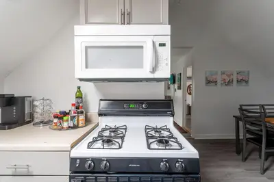 a kitchen with a stove with a microwave above it at Spacious 4BR 1BA Duplex Apartment Near NYC in Bayonne