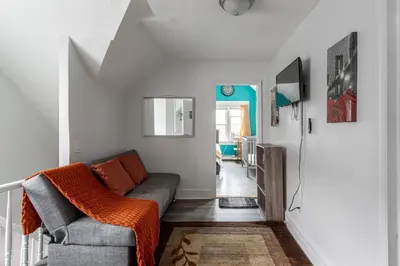 a living room with a couch and a tv at Spacious 4BR 1BA Duplex Apartment Near NYC in Bayonne