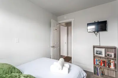 a bedroom with a bed and a tv on a wall at Spacious 4BR 1BA Duplex Apartment Near NYC in Bayonne