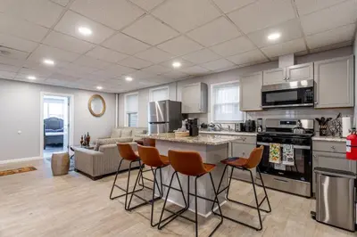 a kitchen with orange bar stools in a living room at Updated 3BR 2BA Apartment Near NYC Airport in Bayonne