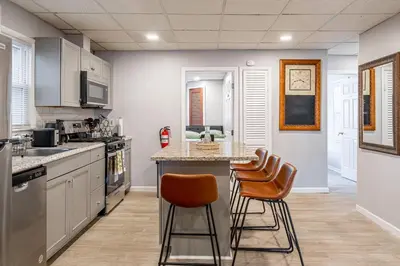 a kitchen with a counter and stools in it at Updated 3BR 2BA Apartment Near NYC Airport in Bayonne