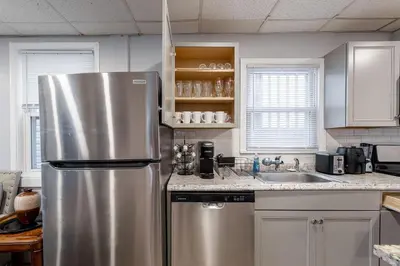 a kitchen with a stainless steel refrigerator and a sink at Updated 3BR 2BA Apartment Near NYC Airport in Bayonne