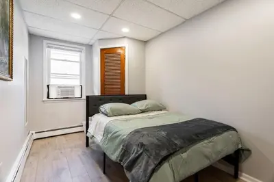 a bedroom with a bed in a room with a window at Updated 3BR 2BA Apartment Near NYC Airport in Bayonne