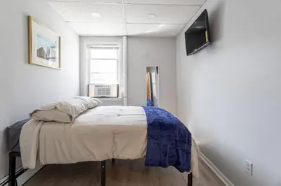 a bedroom with a bed with a tv on the wall at Updated 3BR 2BA Apartment Near NYC Airport in Bayonne