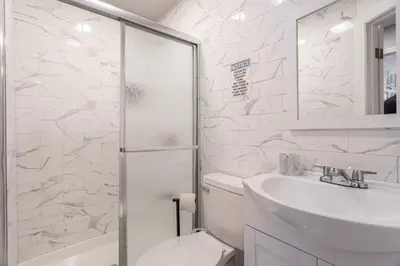 a bathroom with a toilet and a sink and a shower at Updated 3BR 2BA Apartment Near NYC Airport in Bayonne