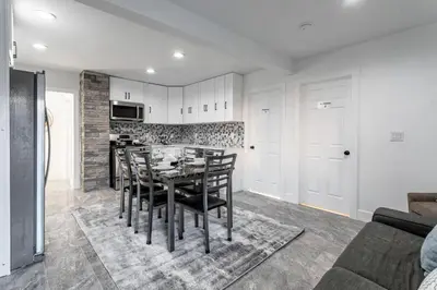 a kitchen and dining room with a table and chairs at The Modern Retreat 4BR 2BA Near NYC and Airport in Bayonne