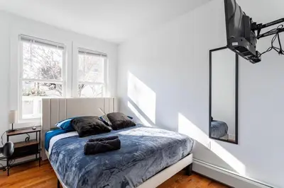 a bedroom with a bed with two pillows on it at The Modern Retreat 4BR 2BA Near NYC and Airport in Bayonne