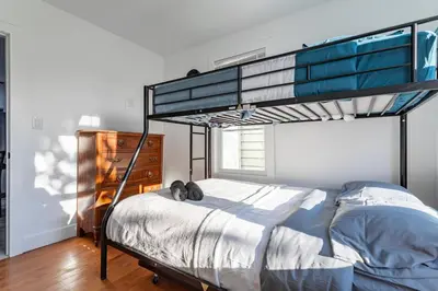 a bedroom with a bunk bed with a cat laying on it at The Modern Retreat 4BR 2BA Near NYC and Airport in Bayonne