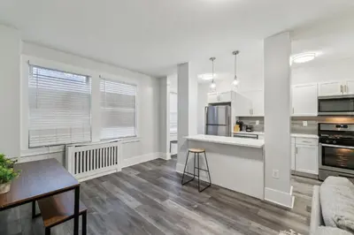 a kitchen and dining room with white cabinets and a table at Fairfax 126 I 1bd1bth University City in Philadelphia