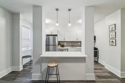 a white kitchen with a counter and a stool at Fairfax 126 I 1bd1bth University City in Philadelphia