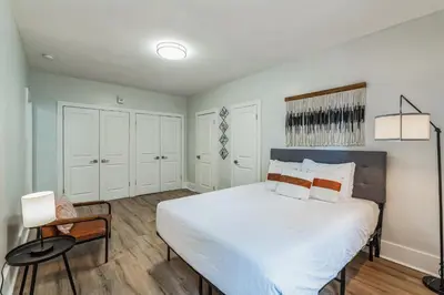 a bedroom with a large white bed and a chair at Fairfax Apartments 303 Spacious 1 Bed 1 Bth in Philadelphia