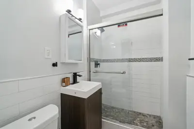 a white bathroom with a sink and a shower at Fairfax Apartments 425 Spacious 1 Bed 1 Bth in Philadelphia