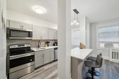 a kitchen with white cabinets and a black appliances at Fairfax Apartments 425 Spacious 1 Bed 1 Bth in Philadelphia