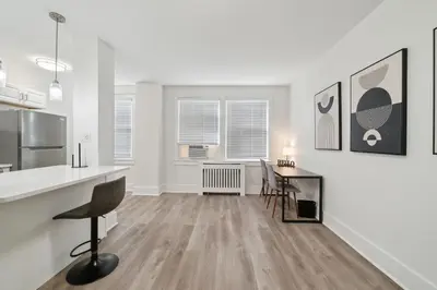a white kitchen with a counter and a table at Fairfax Apartments 603 Spacious 1 Bed 1 Bth in Philadelphia