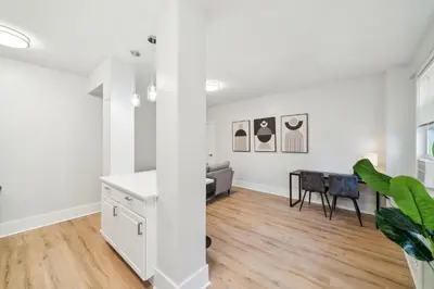 an open living room with white walls and a table at Fairfax Apartments 604 Spacious 1 Bed 1 Bth in Philadelphia
