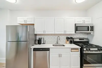 a kitchen with white cabinets and a stainless steel refrigerator at Fairfax Apartments 604 Spacious 1 Bed 1 Bth in Philadelphia