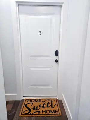 a home sweet home sign on the floor in front of a white door at Cozy apartment near New York City in Jersey City