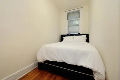a bedroom with a bed with white sheets and a window at Prime Murray Hill 1BR - Near Grand Central in New York
