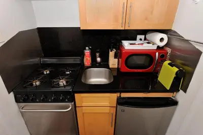 a small kitchen with a microwave and a sink at Prime Murray Hill 1BR - Near Grand Central in New York