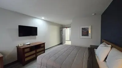 a bedroom with a bed and a tv on the wall at Roosevelt Inn at Roosevelt Blvd, Philadelphia, PA in Philadelphia