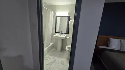 a bathroom with a sink and a toilet and a mirror at Roosevelt Inn at Roosevelt Blvd, Philadelphia, PA in Philadelphia
