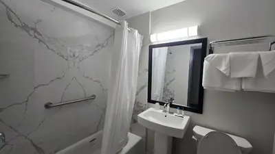 a bathroom with a sink and a toilet and a shower at Roosevelt Inn at Roosevelt Blvd, Philadelphia, PA in Philadelphia