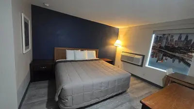 a bedroom with a bed and a blue wall at Roosevelt Inn at Roosevelt Blvd, Philadelphia, PA in Philadelphia